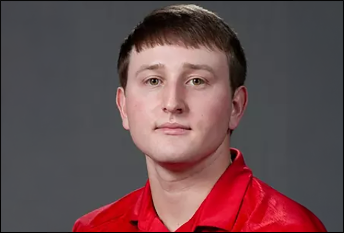Smiling man in red shirt.