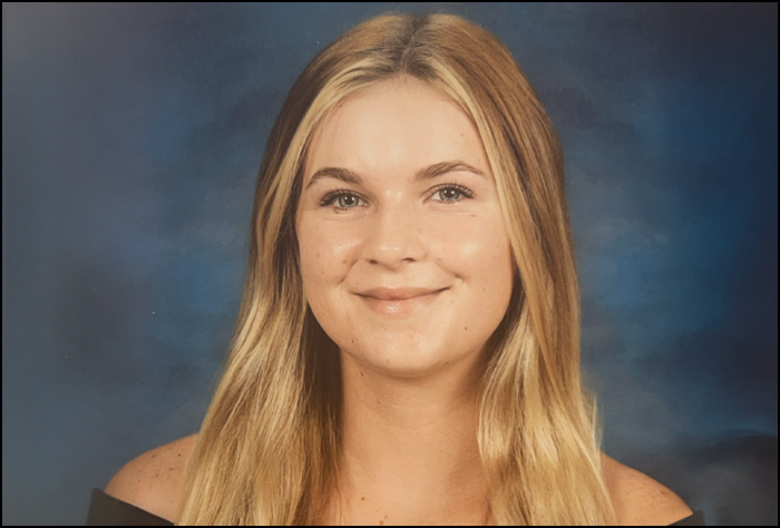 Smiling blonde woman with blue background.