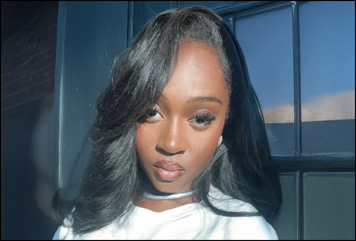 Young woman with a white shirt in front of a window.
