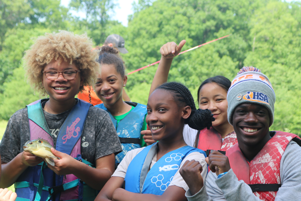 Happy group of young teens outside fishing.
