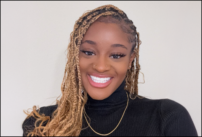 Smiling woman white a black shirt in front of a white background.