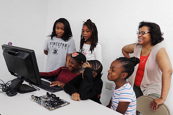 CampBYOC kids gathered around a computer